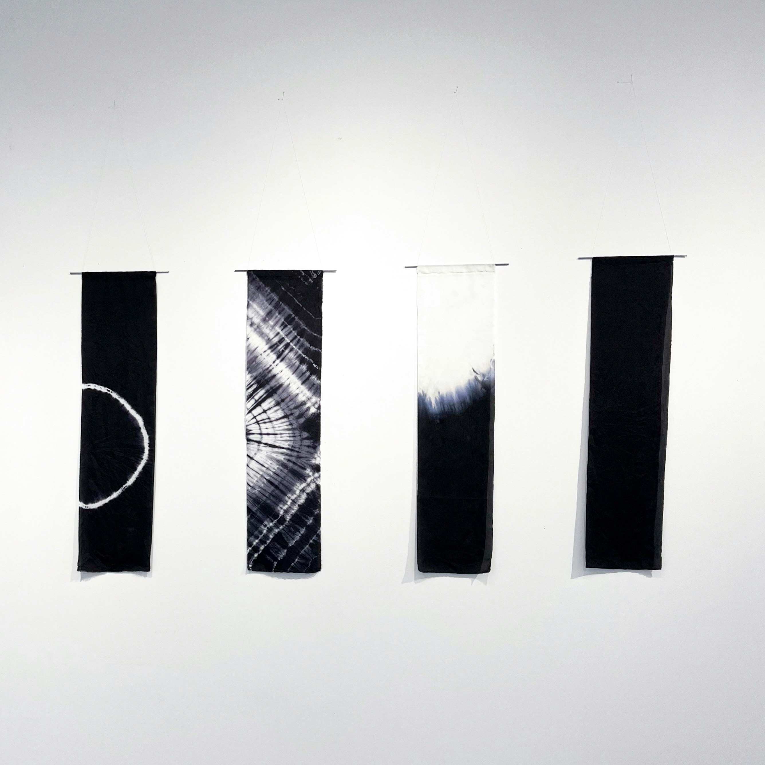 Four hand dyed silk strips hang from steel bars created by Danielle Gadus.