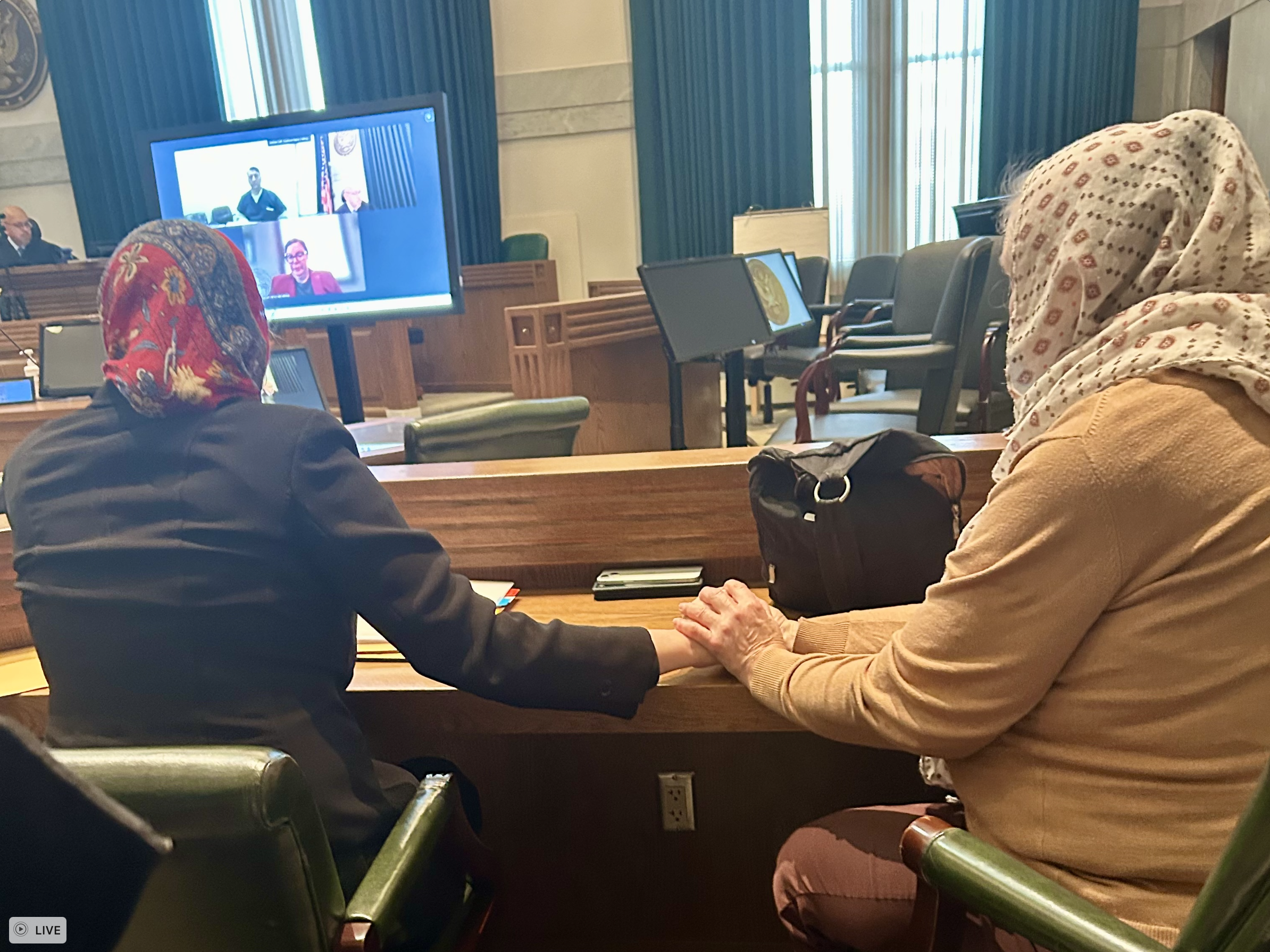 Melissa and Ann holding hands at Zahid's habeas hearing, December 22, 2025