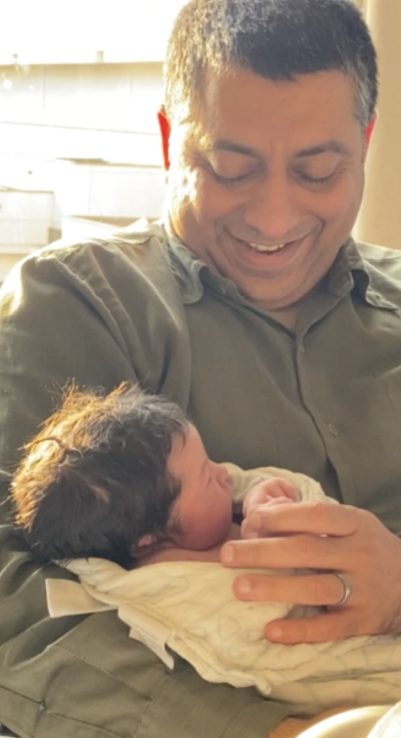 Zahid holding newborn Salma, 2023