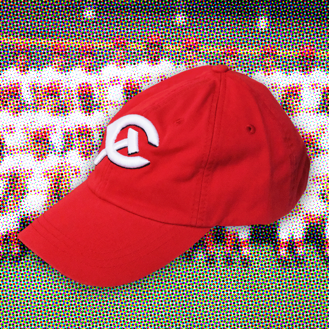 A Red baseball cap with a white, wishbone shaped letter "C" embroidered on the front. A white embroidered hammer intersects bottom of the letter "C." 