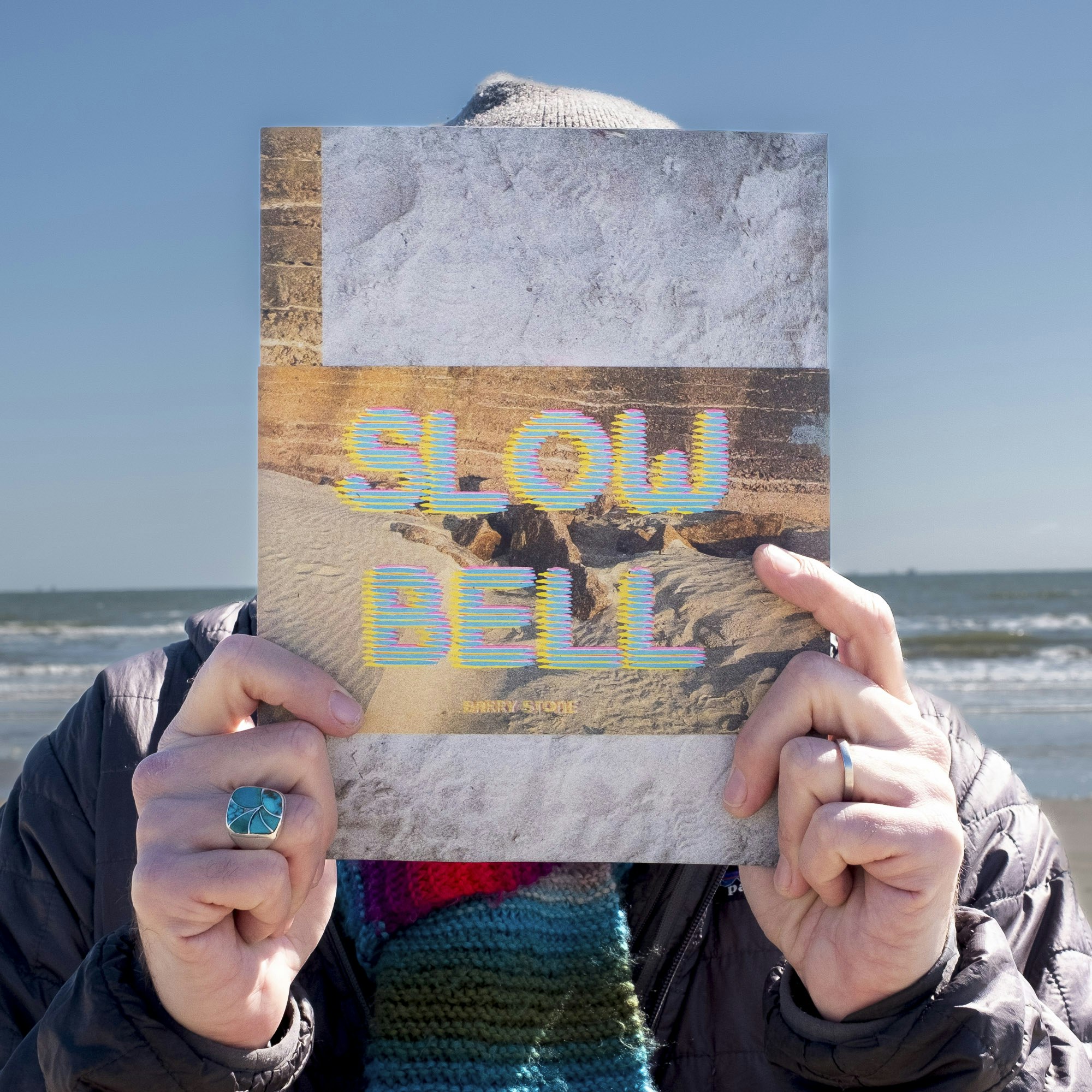 holding the assembled book with belly band on Galveston Beach.