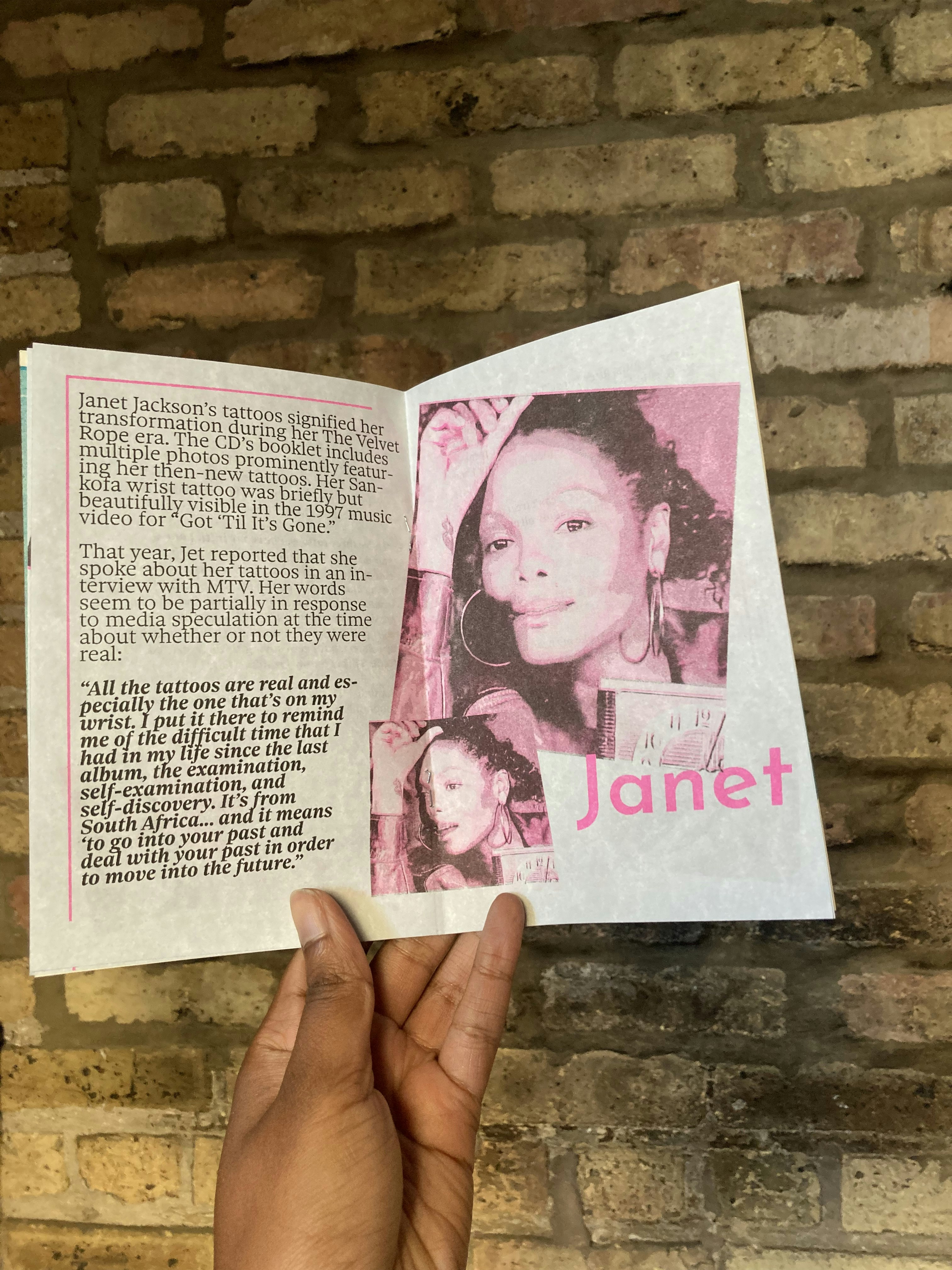 The centerfold of Tatted featuring two images of Janet Jackson showing the tattoo on her wrist. The pages frature a quote from Janet Jackson talking about her tattoos.