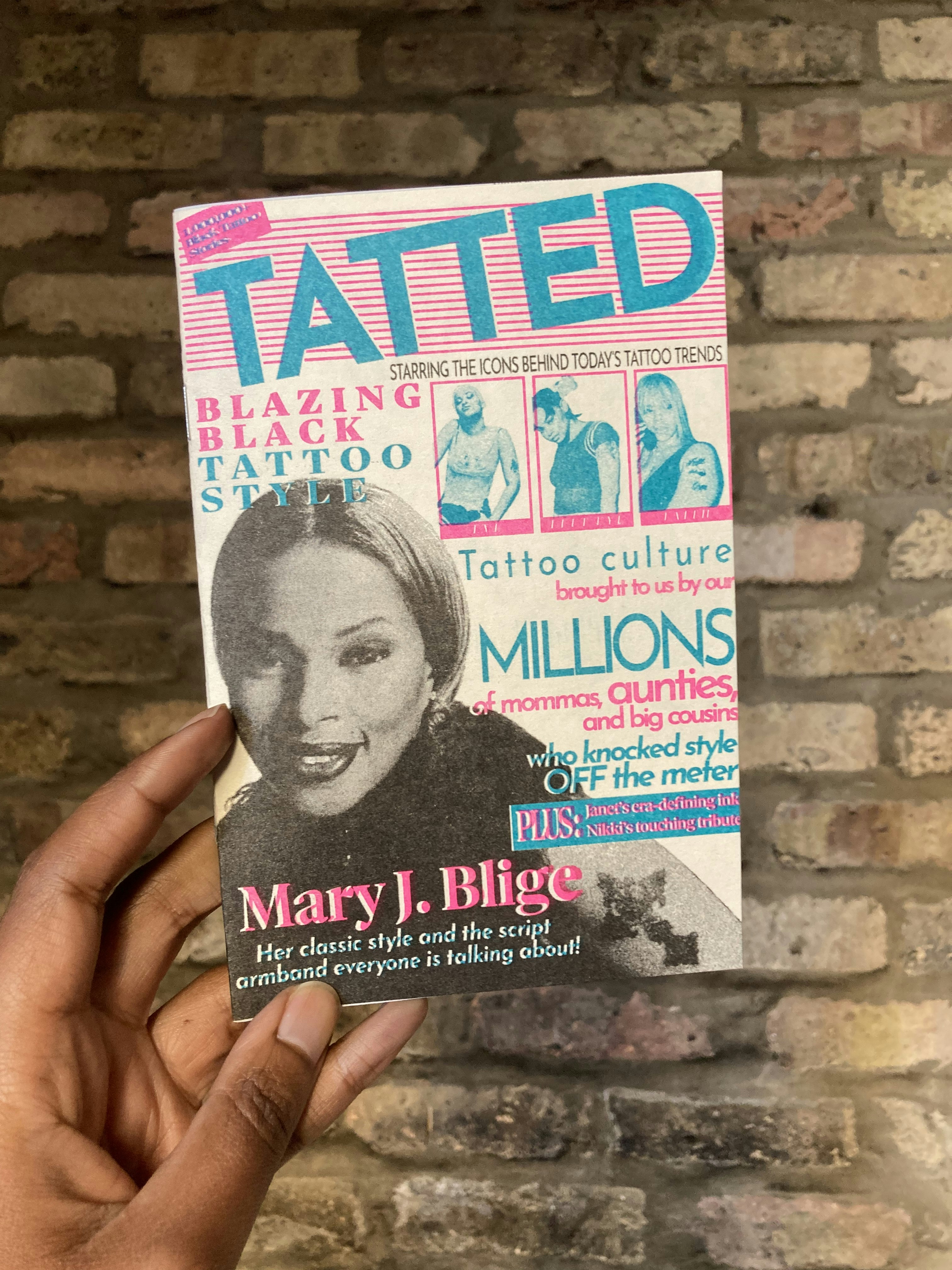 A blue pink and black cover of a mini magazine called Tatted featuring a headshot of Mary J. Blige showing a cross tattoo on her arm