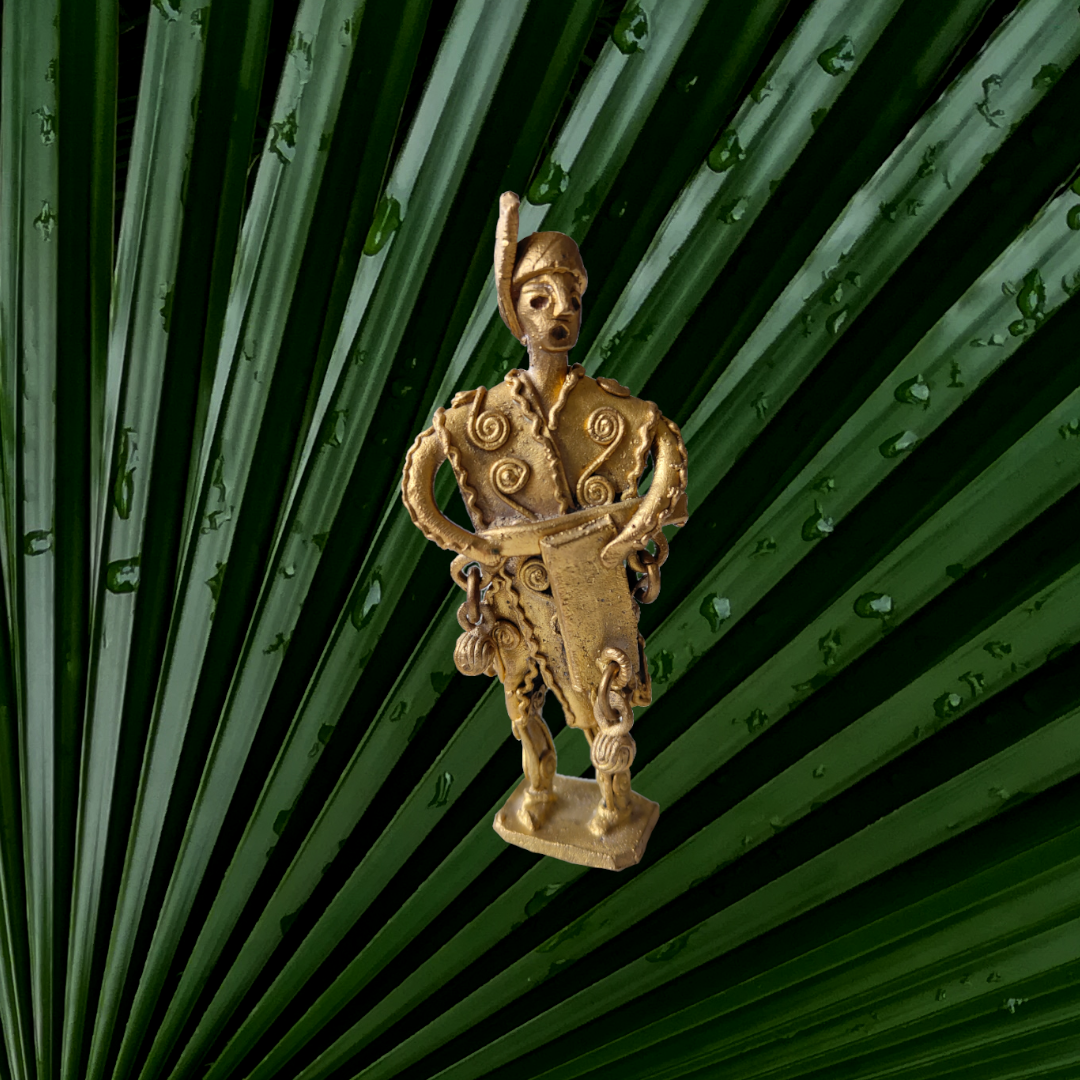 A T'boli brass sculpture depicting a Datú, purchased from Poblacion Market Central in Davao City against an anahaw leaf