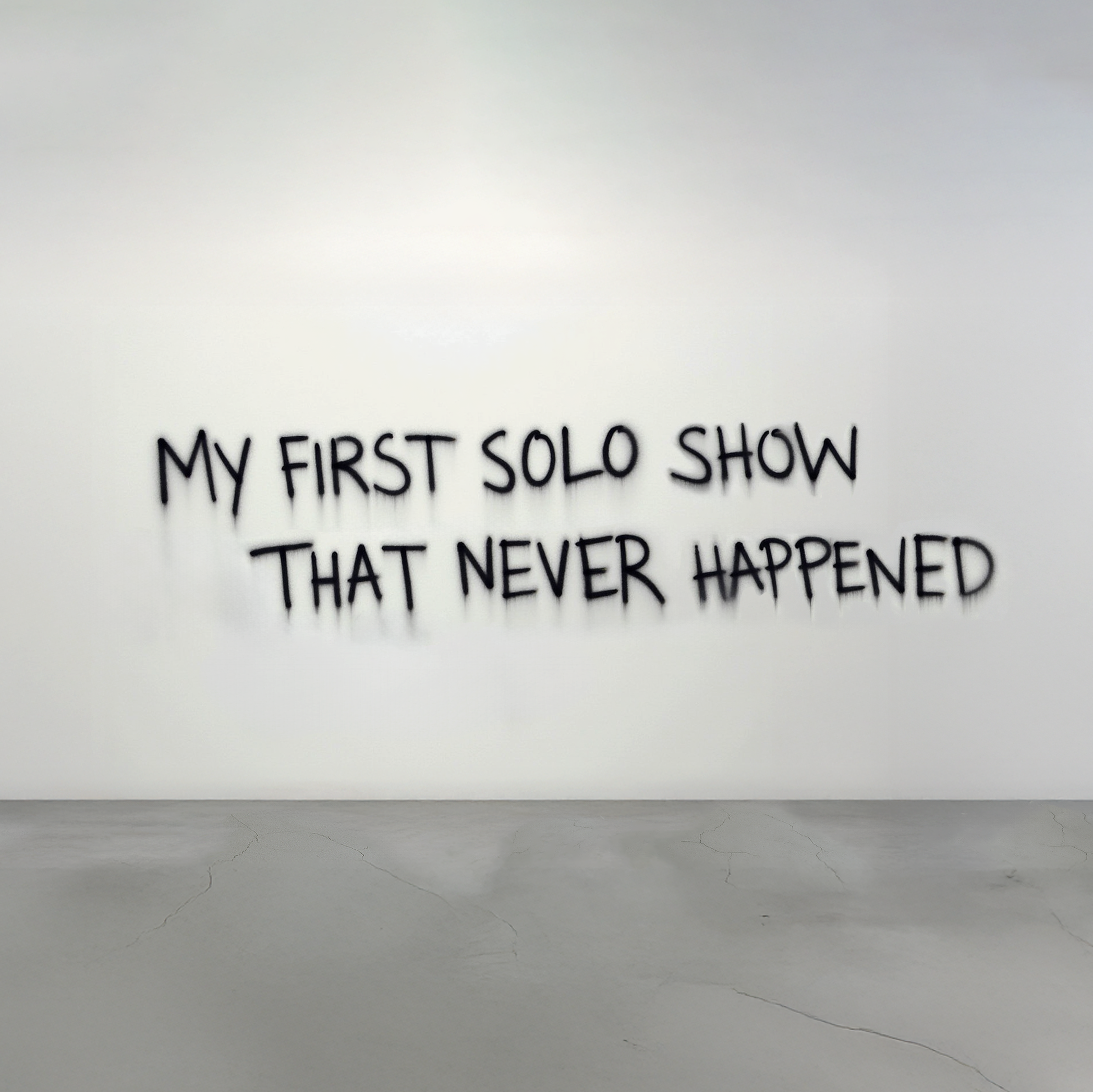 A handwritten text on a digitally reconstructed white wall above aa light gray, concrete floor, reads: "my first solo show that never happened." 