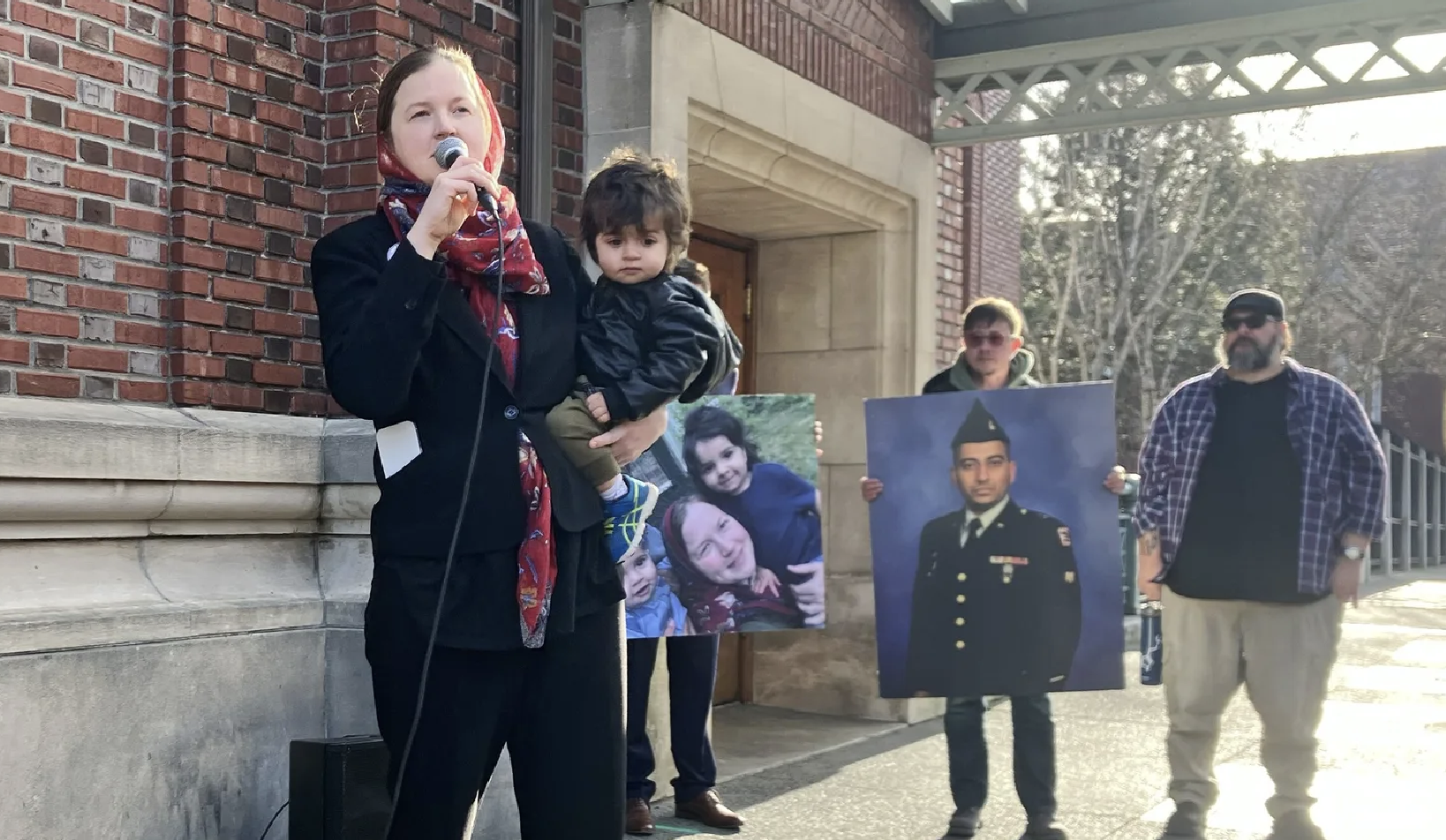 Melissa holding Adil and a microphone, at the press conference announcing Zahid's release.