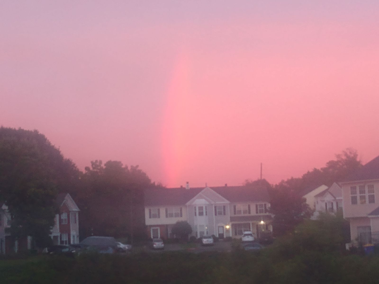 Rainbow at dusk over suburban street scene